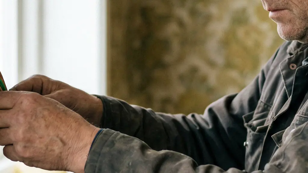 Mains d'un électricien professionnel travaillant sur un panneau de mur technique moderne, montrant un système de gestion de câbles bien organisé dans une maison en cours de rénovation.