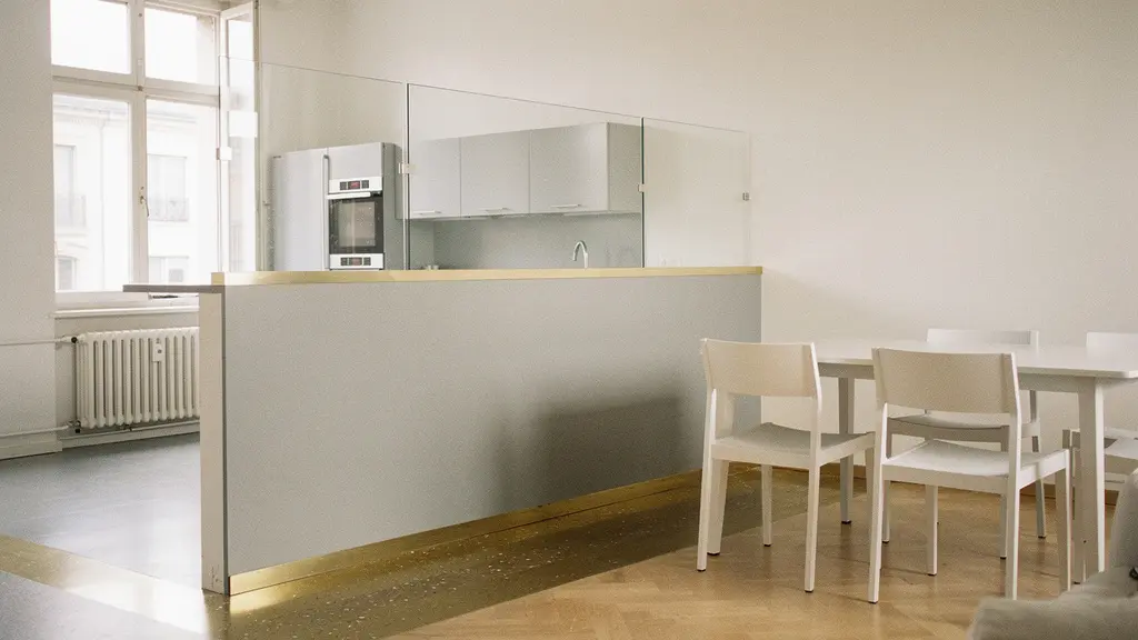 Grande pièce de vie d’un T3 des années 80 après ouverture d’une cloison, avec une lumière naturelle qui traverse l’espace et agrandit visuellement le volume.